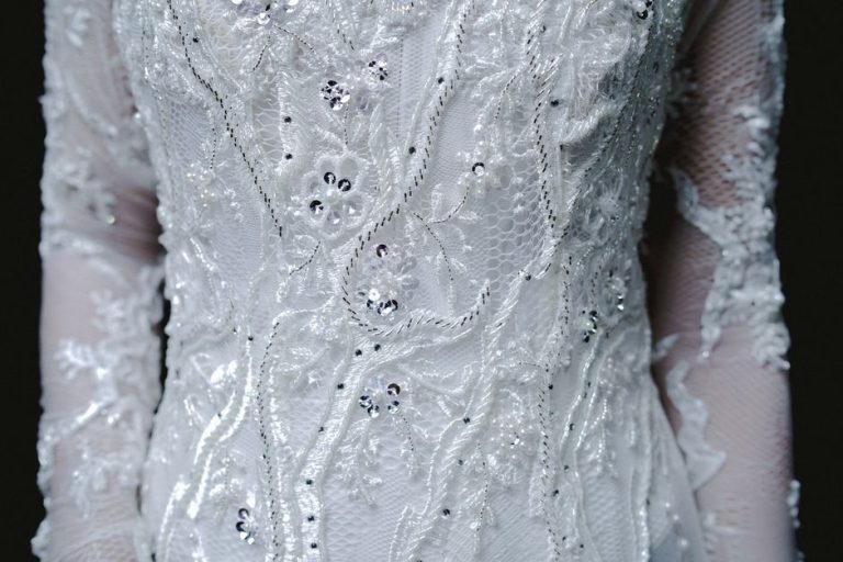 Detalle de vestido de novia de alta costura con bordados y cuentas en ceremonia elegante