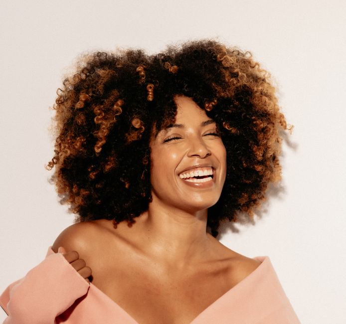 Mujer con corte curly bob y pelo rizado natural en verano