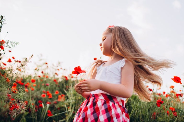 Niña pequeña jugando en jardín con flores, evocando la celebración del cumpleaños de Lilibet