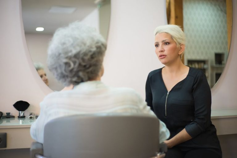 Mujer madura con cabello saludable y brillante en salón de belleza