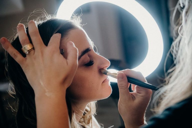 Mujer aplicándose colorete para maquillaje de verano con tono bronceado