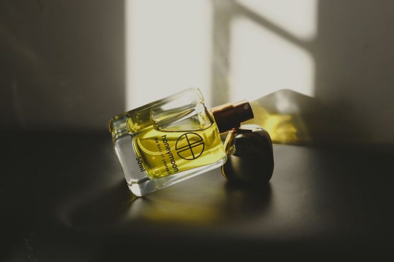 Botellas de perfume elegantes sobre fondo minimalista que evocan sofisticación y lujo asequible