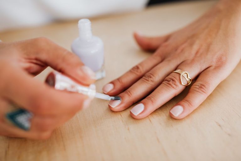 Manicura en azul celeste sobre manos femeninas, tendencia de esmalte de uñas para el verano