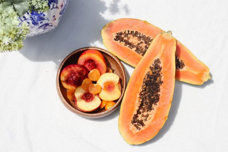 Colección de perfumes frutales de verano con notas de melocotón, fresa y coco sobre fondo luminoso