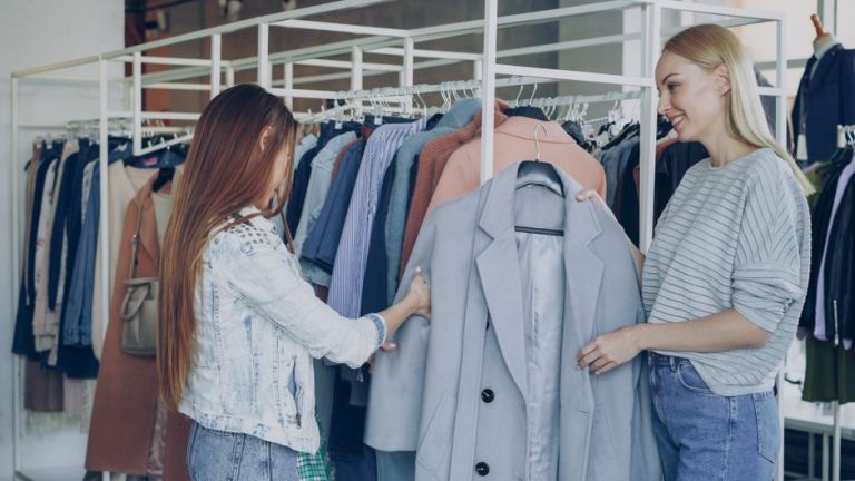 Chaquetas de mujer en tonos neutros colgadas en perchero de tienda