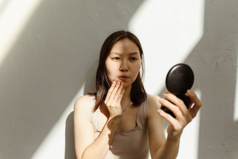 Mujer aplicando protector solar facial en rutina de cuidado de piel de verano