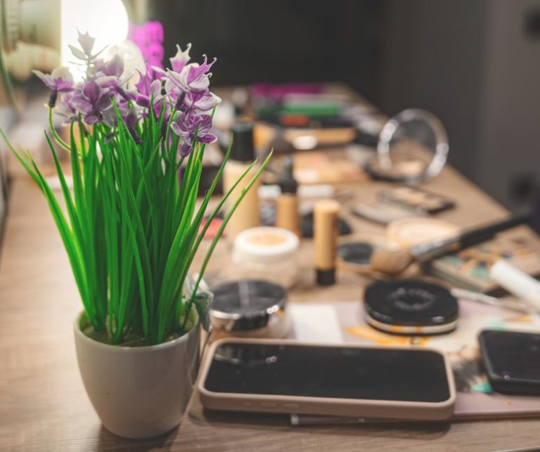 Pintalabios rojo sobre mesa con productos de maquillaje