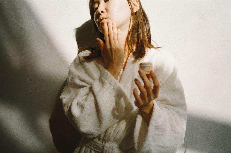 Mujer aplicando crema hidratante facial en su rutina de cuidado de la piel