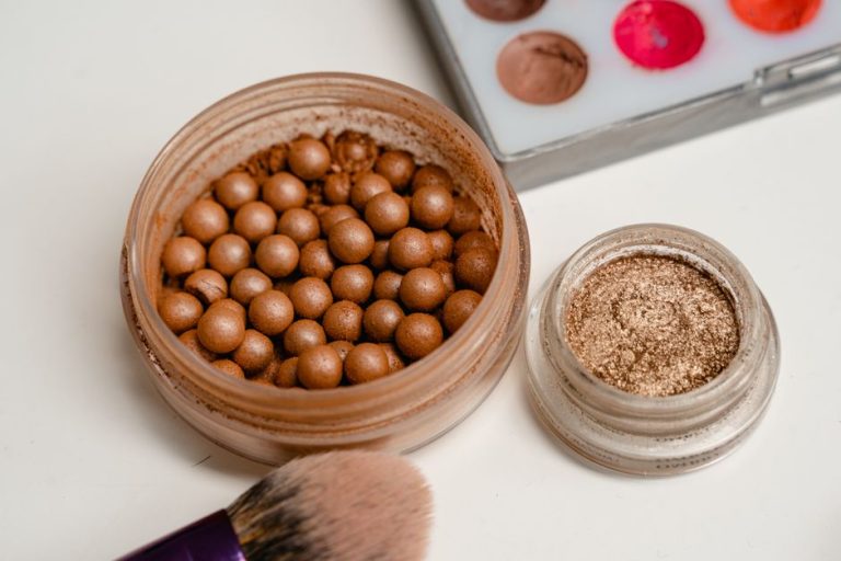 Brochas de maquillaje y polvos compactos en tonos beige y caramelo