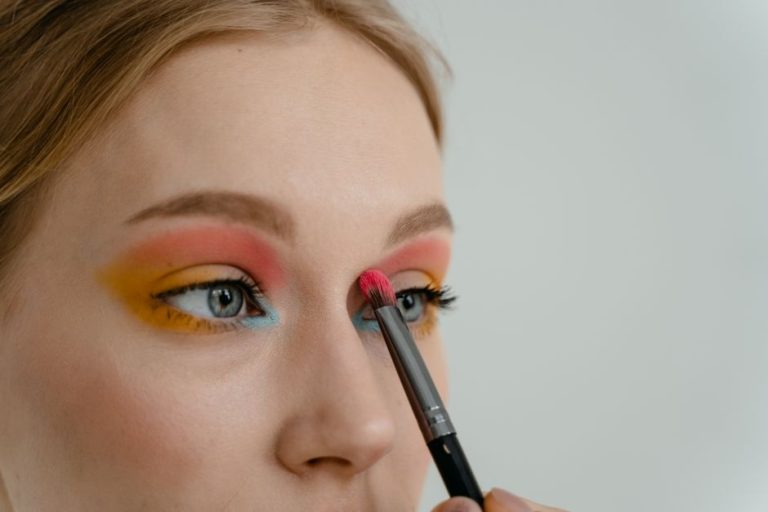 Lápiz de ojos y herramientas de maquillaje sobre superficie clara