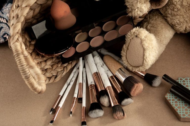 Paleta de sombras de ojos en tonos neutros con brocha de maquillaje