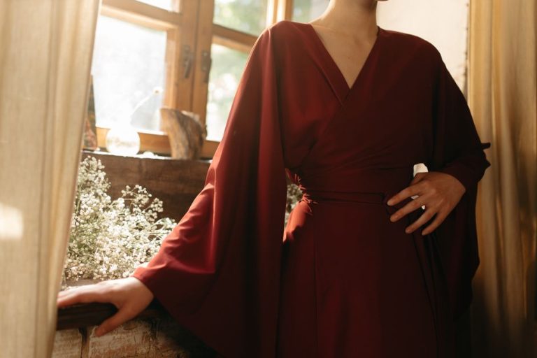 Vestido midi burdeos con hombros abullonados y espalda descubierta en evento elegante